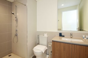 A modern bathroom with a shower, toilet, sink, and mirror. - Spacious 3BHK Townhouse-Emaar South Golf (Dubai)