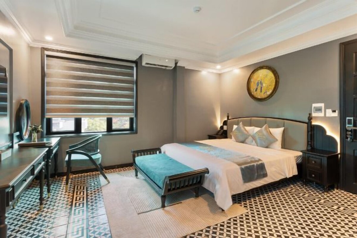 A bedroom with a bed, bedside tables, a desk, and a chair.