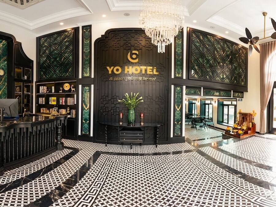 Eine Lobby mit einer Rezeption, einer großen Uhr und einem Schild mit der Aufschrift 'YO HOTEL'.