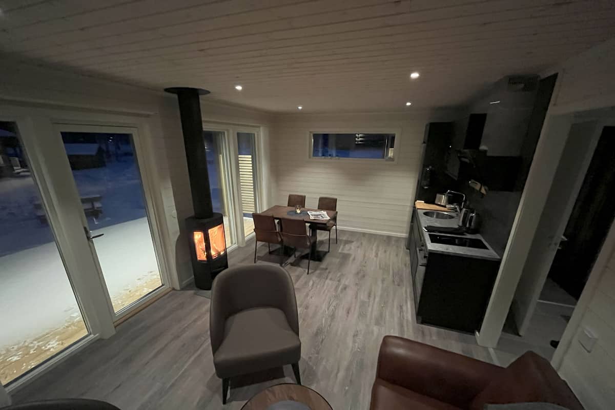 Uma sala de estar moderna com lareira, área de refeições e cozinha.