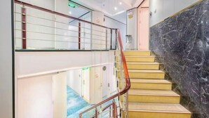 A modern hotel interior with a marble staircase, glass railings, and a clean, well-lit hallway. - Yuedu Hotel · Select (Guangzhou Beijing Road Pedestrian Street West Gate Metro Station Branch) (Guangzhou)