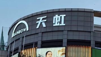 A building with a curved facade and a sign that reads "RAINBOW" and "天虹".