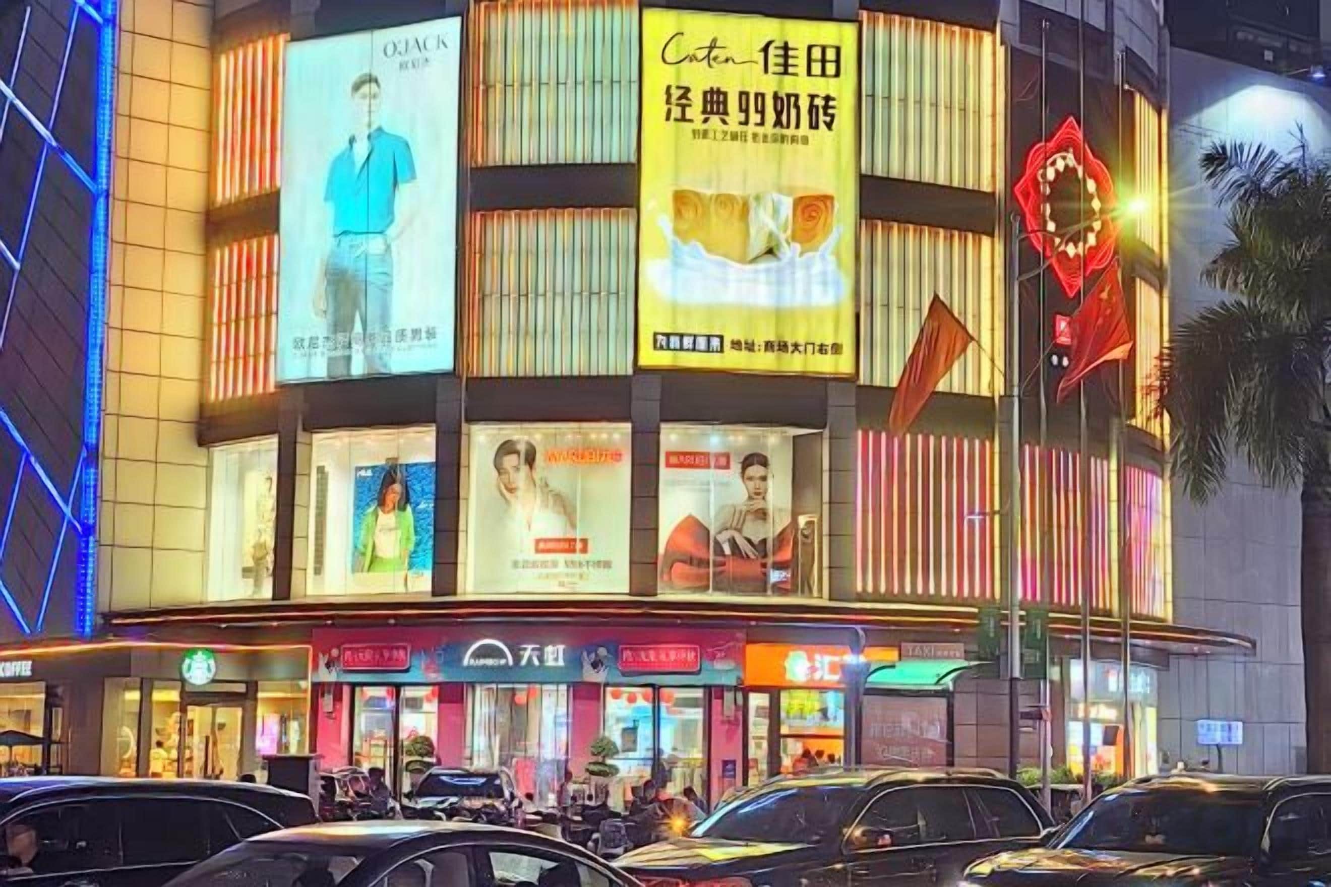 A multi-story building with illuminated signage and advertisements.