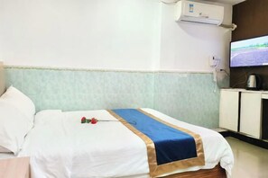 A hotel room with a bed, a television, and a minibar. - Lianchang Hotel (Shenzhen)