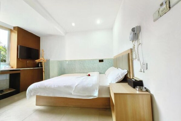 A modern hotel room with a bed, bedside table, and a TV mounted on the wall. - Lianchang Hotel (Shenzhen)