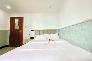 A hotel room with a bed, a wooden door, and a light-colored headboard. - Lianchang Hotel (Shenzhen)