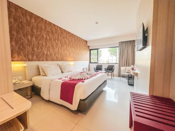 A hotel room with a large bed, bedside tables, a desk, and a TV. - Sahid Bandara Soekarno Hatta (Tangerang)