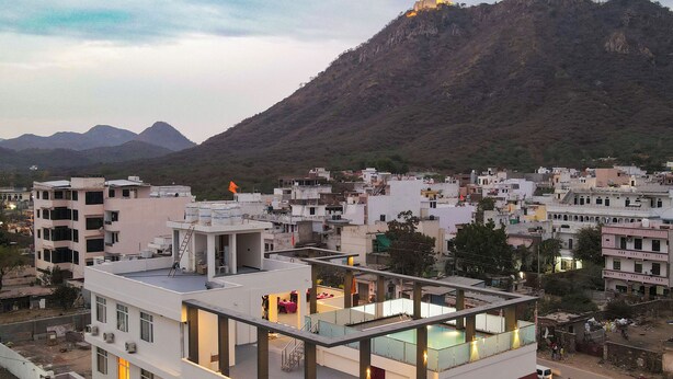 A modern building with multiple floors, balconies, and a rooftop area. - Hotel Aranyasutra (Udaipur)