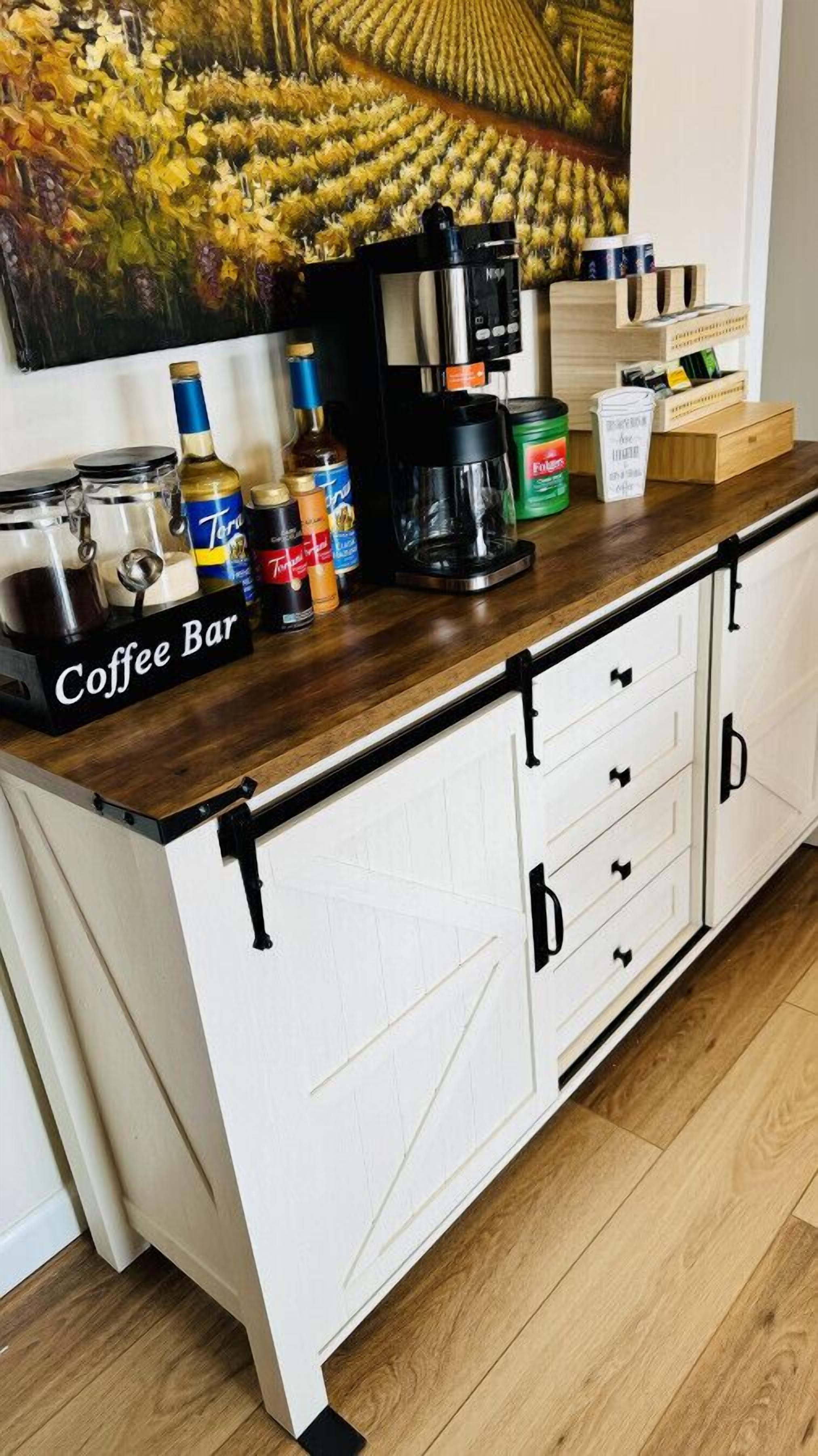 A kitchen counter with a coffee bar setup, including a coffee machine, jars, and bottles.