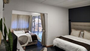 Ein Hotelzimmer mit zwei Betten, einem großen Fenster und Blick ins Freie.