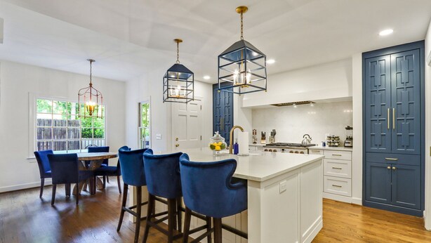 A modern kitchen with a central island, bar stools, pendant lights, and a view of the outdoors. - Buckhead 4-BDM/3.5 Bath, chic house, w baby grand Piano. Mins to Shopping/Gov Mn (Atlanta)