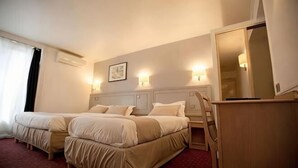 Una habitación de hotel con dos camas, un escritorio, una silla y un espejo grande.