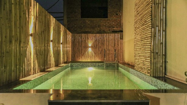 A spa pool with bamboo walls and a tiled floor. - 3BHK w/Pool - Sunset Palazzo by Universe Villas (Karjat)