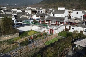Un village traditionnel avec des bâtiments blancs, une cour centrale et un petit pont.