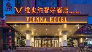 The Vienna Hotel entrance with a prominent sign, a set of stairs leading up to the doors, and a modern building facade in the background. - Vienna Classic Hotel (Shijiazhuang Jianhua Street Beisong Subway Station) (Shijiazhuang)