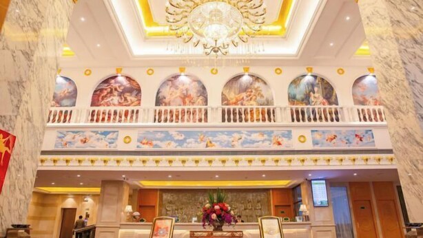 A hotel lobby with marble walls, a chandelier, a balcony with artwork, and a reception desk. - Vienna Classic Hotel (Shijiazhuang Jianhua Street Beisong Subway Station) (Shijiazhuang)
