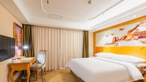 A hotel room with a bed, a desk, a chair, a TV, and a large wall mural. - Vienna Classic Hotel (Shijiazhuang Jianhua Street Beisong Subway Station) (Shijiazhuang)