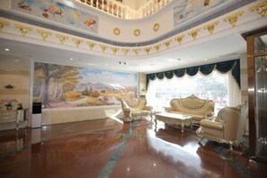 Un rebedor ampli amb un mural gran, una escala majestuosa i una disposició d'àrees d'estar elegants.