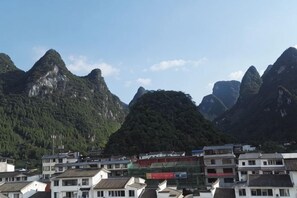 A mountainous landscape with buildings in the foreground. - Shengjin Hotel (Yangshuo)
