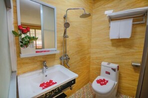 A bathroom with a white sink, a shower, and a toilet. - Shengjin Hotel (Yangshuo)