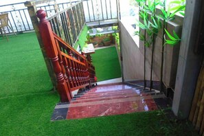A wooden staircase leading to a green area with artificial grass. - Shengjin Hotel (Yangshuo)