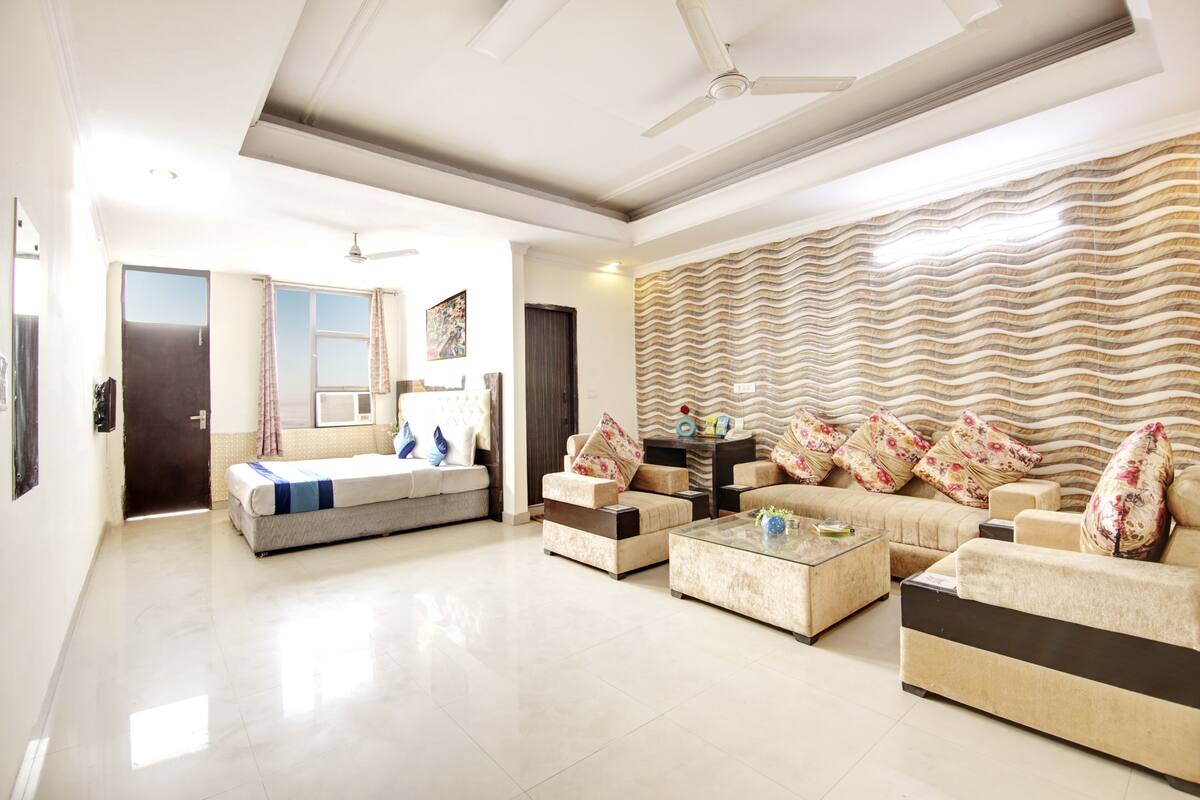 A spacious living room with a sofa set, a coffee table, and a patterned wall.