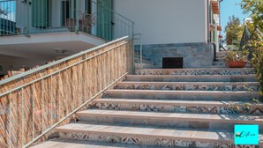A staircase with patterned tiles leading to a balcony with green shutters. - Villa Ortensia (Mazzaforno)