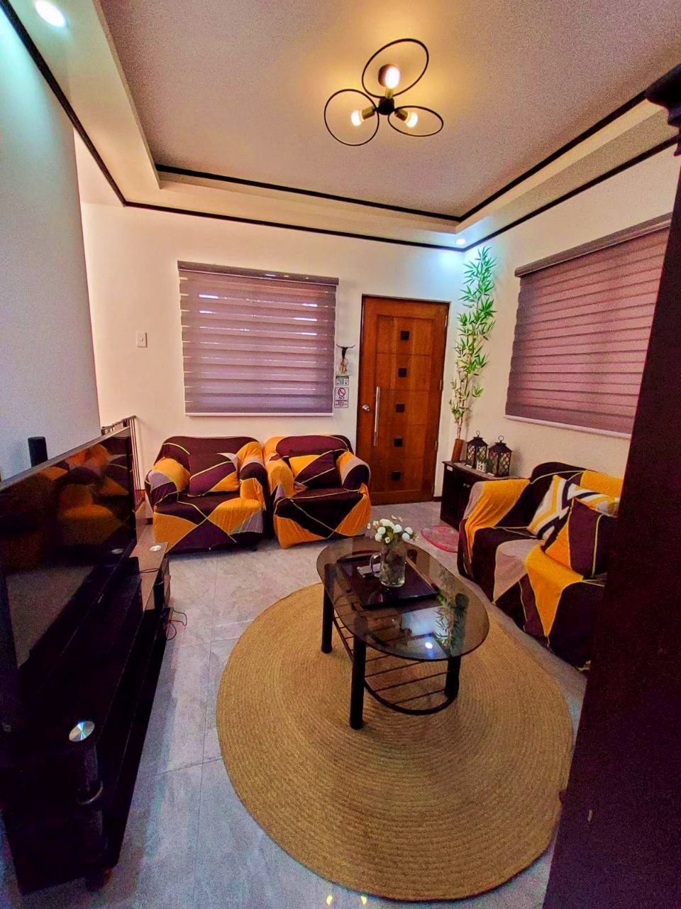 A living room with a sofa set, a coffee table, and a piano.