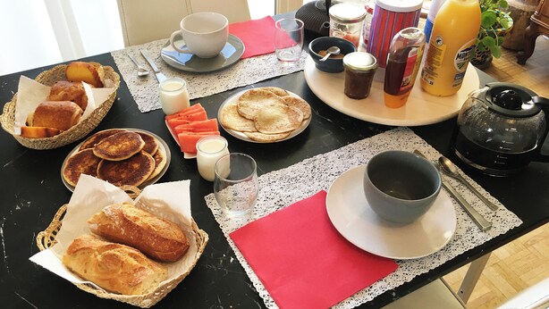 A breakfast table with bread, pastries, and beverages. - Juste une Chambre Chez L'habitant (Saint-Sébastien-sur-Loire)