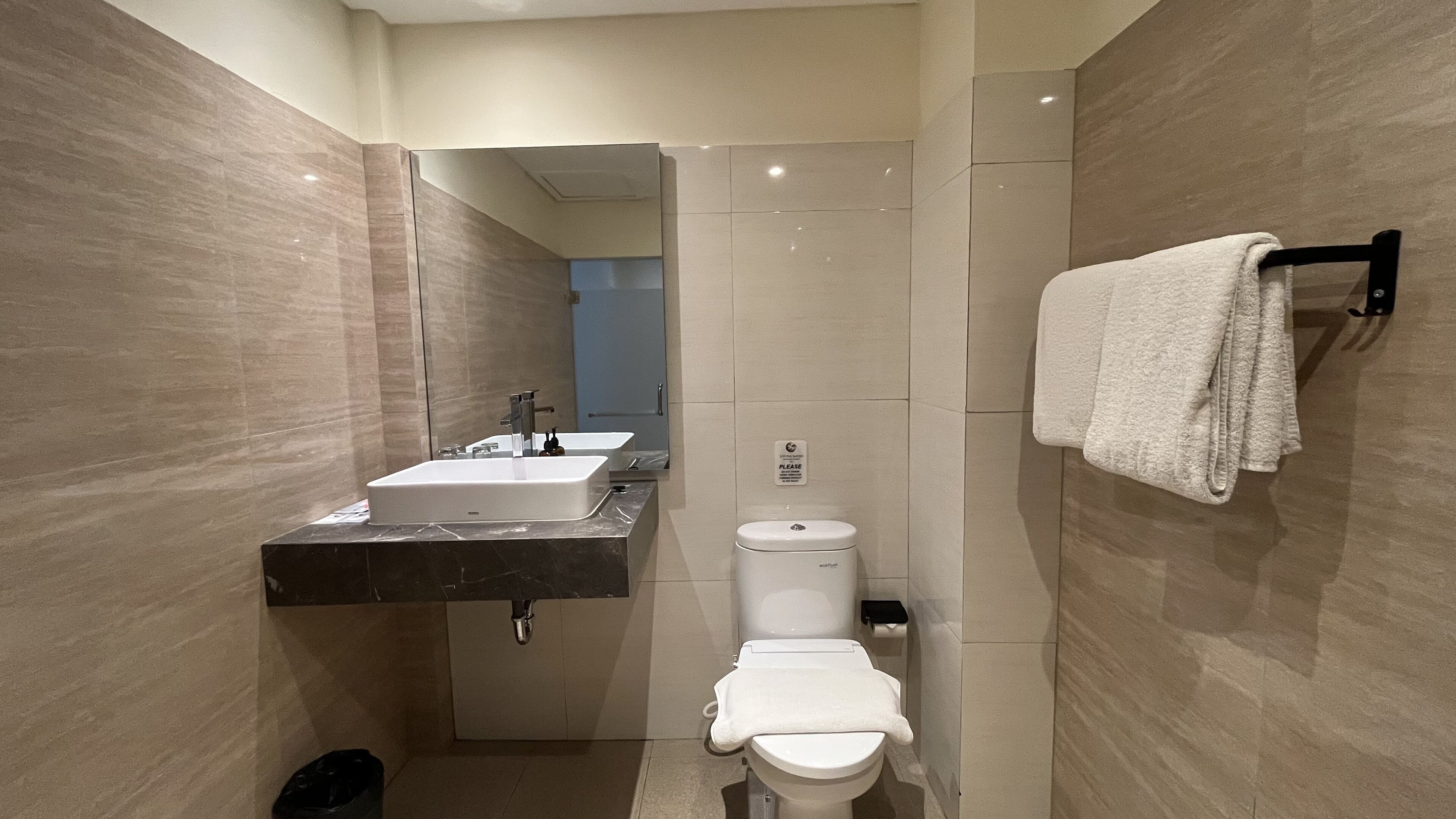 Un baño pequeño con lavamanos, inodoro y toallero.