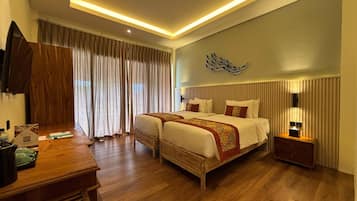 A hotel room with a large bed, bedside tables, a desk, and a wall-mounted TV.