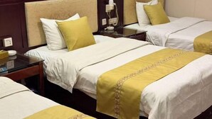 A hotel room with two beds, each with a headboard, a bedside table, and a telephone. - Jixuan Hotel (Zhongshan)