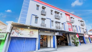 Un immeuble à plusieurs étages doté d’une façade moderne, avec des balcons et de grandes fenêtres.