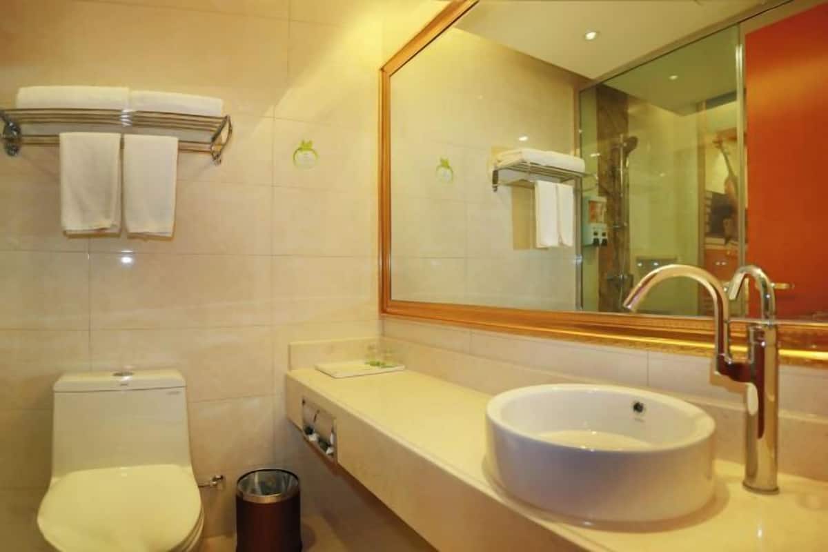 A bathroom with a toilet, sink, and mirror.