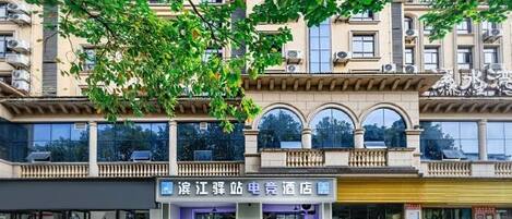 A hotel with a ground-level entrance, a balcony, and a sign indicating it is a hotel.