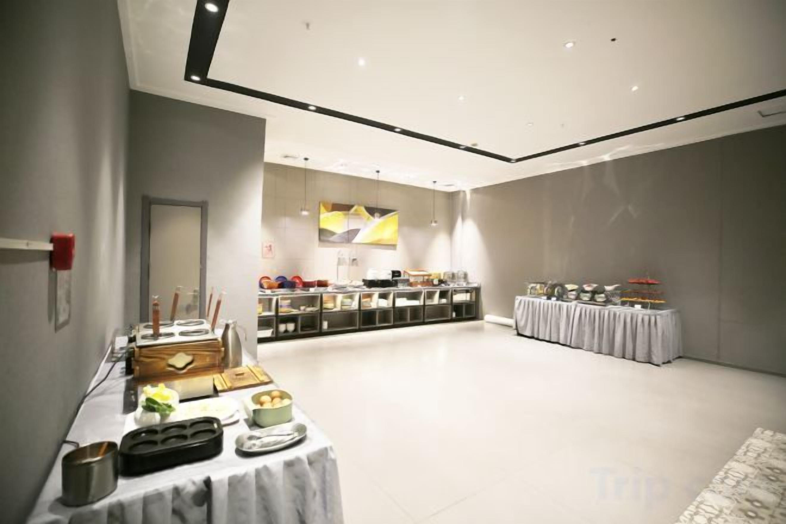 Amplia sala con una mesa de buffet, un mostrador de recepción y una zona de estar.