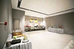 Une pièce spacieuse comprenant un buffet, un comptoir d’accueil et un espace salon.
