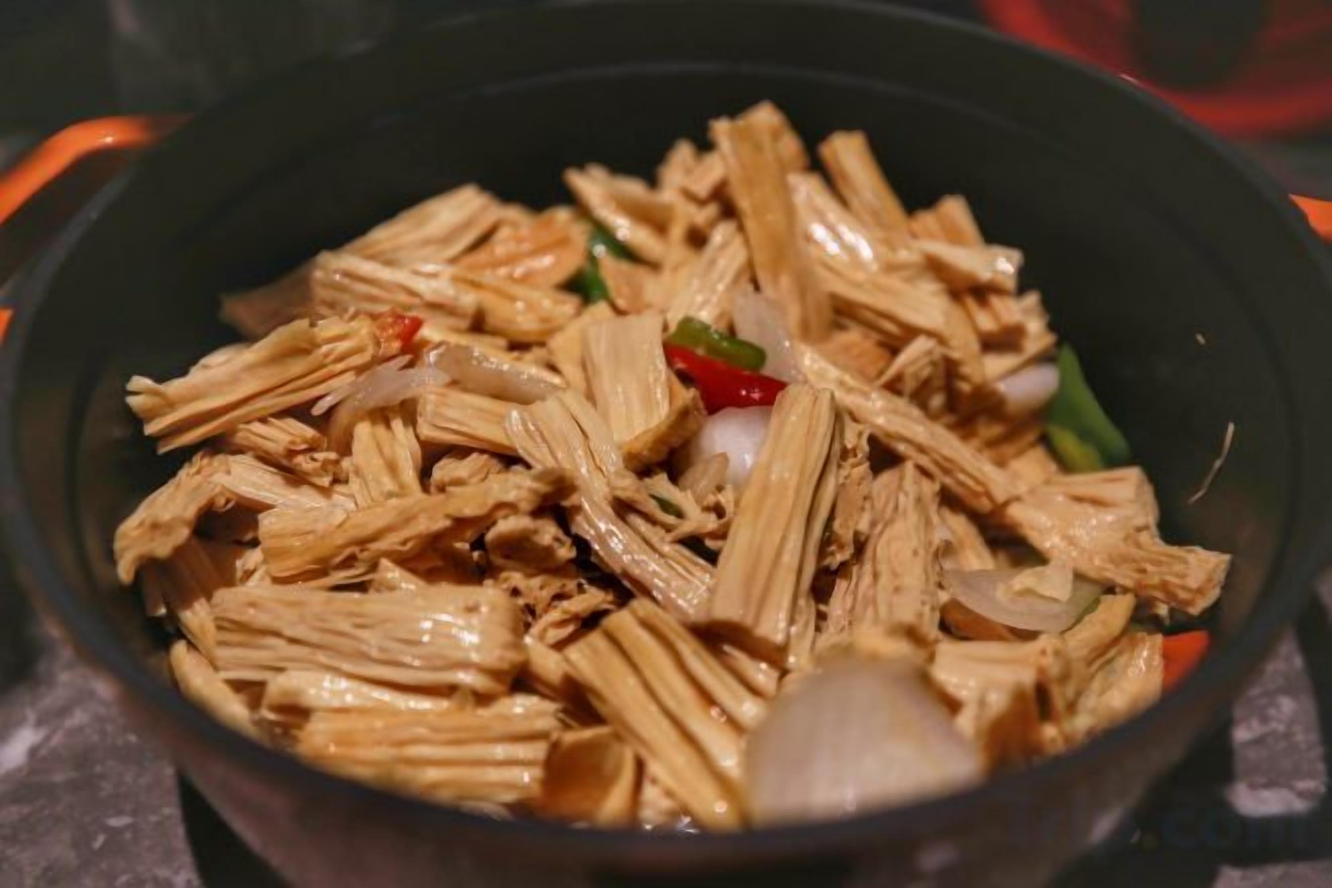 A cooking pan with shredded meat and vegetables.