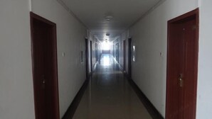 Un pasillo largo y estrecho con puertas a ambos lados, que conduce a un extremo luminoso.