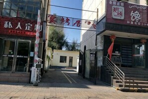 A building with a sign that reads 'Hotel' and a staircase leading to the entrance.