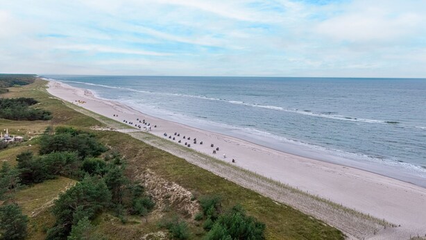 A beach with a row of beach chairs and umbrellas along the shore. - Semi-detached house Villa an der Düne in the Baltic seaside resort of Dierhagen (Ostseebad Dierhagen)