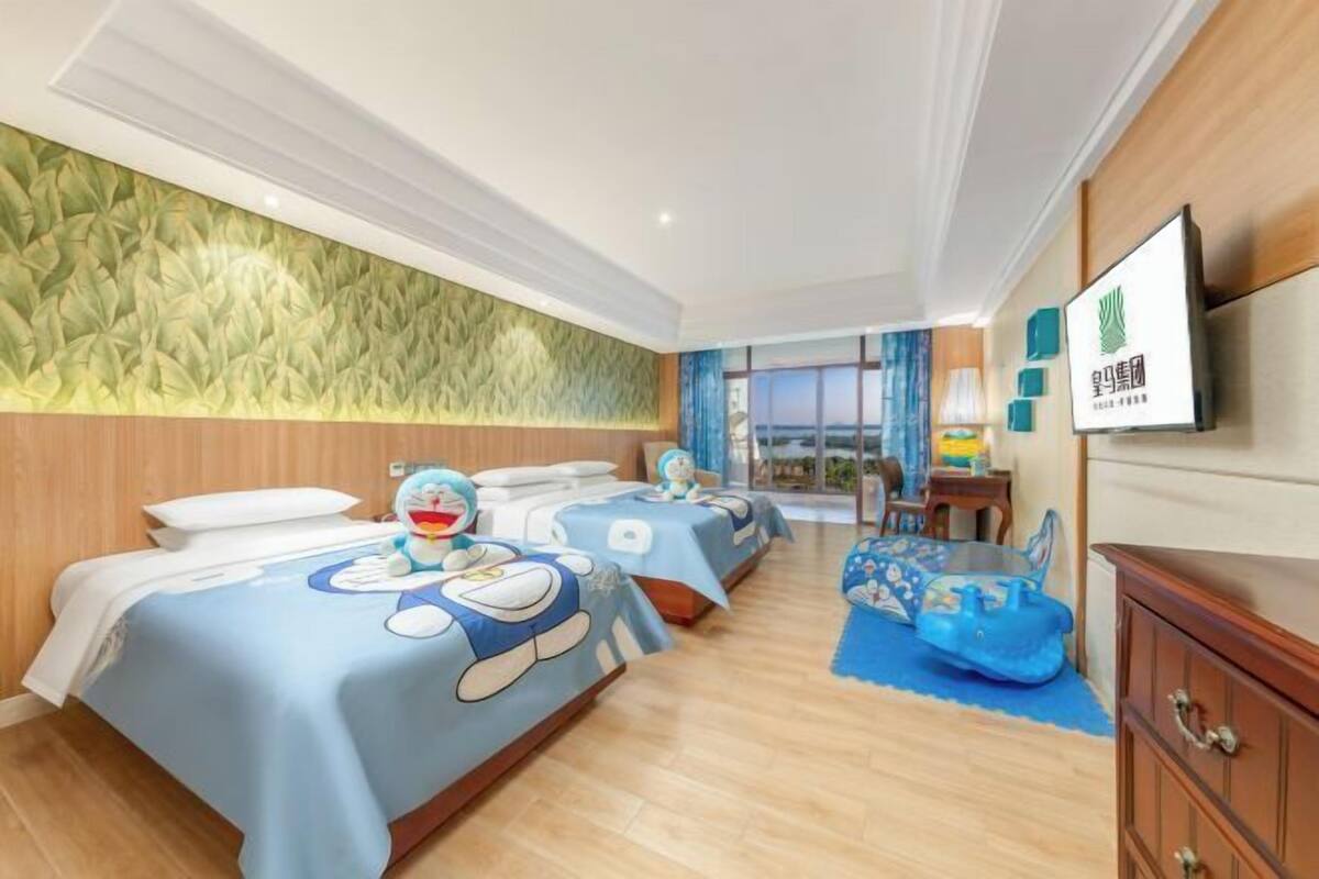 A hotel room with three beds, a TV, a wooden dresser, and a view of the outdoors.