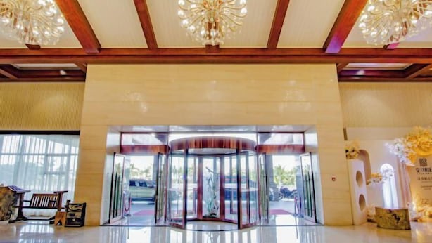 A lobby with a revolving door, chandeliers, and a reception desk. - Real Madrid Holiday Island Style Hotel (Haikou Qilou Old Street) (Haikou)