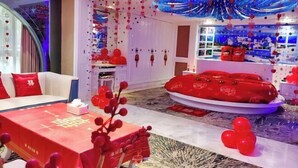 A room with a red and white color scheme, a sofa, a table with a red tablecloth, and a decorative ceiling. - Real Madrid Holiday Island Style Hotel (Haikou Qilou Old Street) (Haikou)