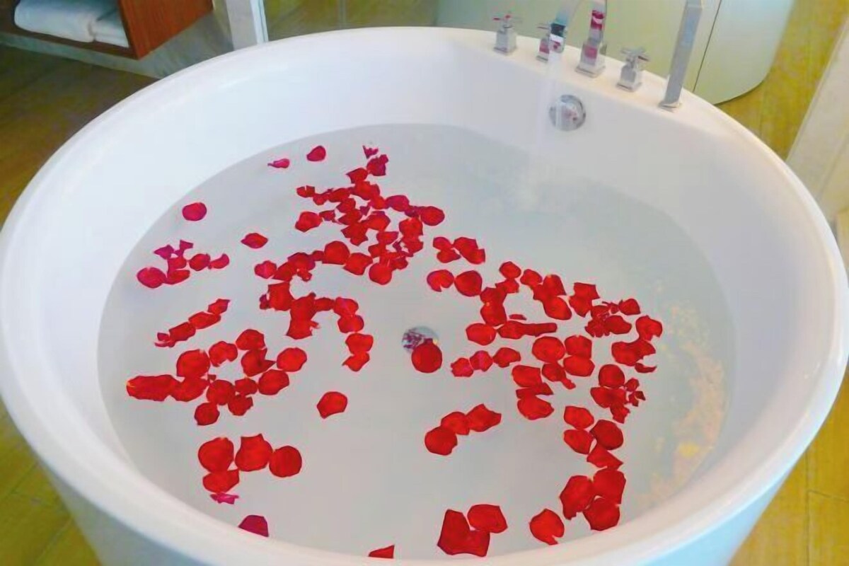 A bathtub filled with rose petals.