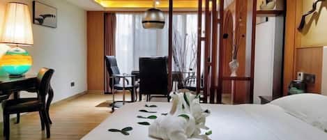 Ein Hotelzimmer mit Bett, Schreibtisch mit Lampe, Stuhl und einer dekorativen Vase.