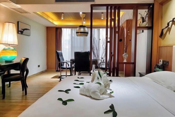A hotel room with a bed, a desk with a lamp, a chair, and a decorative vase. - Real Madrid Holiday Island Style Hotel (Haikou Qilou Old Street) (Haikou)
