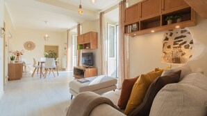 A modern living room with a sofa, television, and wooden cabinets. - Linda Apartment 2 in Como (Como)