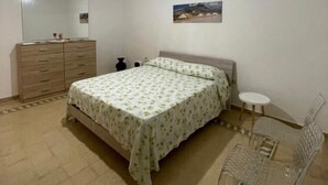 A bedroom with a bed, a dresser, a small table, and a chair. - Garden villa – your relaxed base to explore West Sicily (Custonaci)