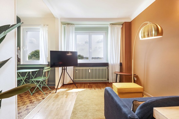 Bright and cozy living space with a comfortable sofa and flat-screen TV, perfect for relaxing after a day of exploring Luxembourg.